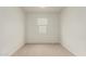 An empty carpeted bedroom with a large window bringing in natural light at 3480 N 307Th Dr, Buckeye, AZ 85396