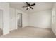 Spacious bedroom featuring neutral carpet, a ceiling fan, and an en-suite bathroom entrance at 3480 N 307Th Dr, Buckeye, AZ 85396