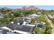 An aerial view of a neighborhood showcases solar panels, pools, desert landscaping, and mountain views at 3653 E Highland Ave, Phoenix, AZ 85018