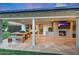 Covered patio with an outdoor dining area and fireplace, offering access and views to the lush backyard at 3653 E Highland Ave, Phoenix, AZ 85018