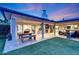 Covered patio with comfortable seating, dining area, fireplace, and a view of the green lawn at 3653 E Highland Ave, Phoenix, AZ 85018