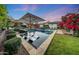 Stunning backyard showcasing a sparkling pool, lounge areas, and manicured lawn at 3653 E Highland Ave, Phoenix, AZ 85018