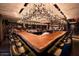 Elegant bar area featuring a unique wooden countertop, stylish seating, and artistic overhead lighting at 3653 E Highland Ave, Phoenix, AZ 85018
