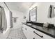 Stylish bathroom with a black countertop, patterned floor, and modern fixtures for a touch of luxury at 3653 E Highland Ave, Phoenix, AZ 85018