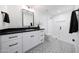 Bright bathroom featuring a black countertop, white cabinets, and a glass shower with designer flooring at 3653 E Highland Ave, Phoenix, AZ 85018