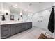 Elegant bathroom with dual sinks, sleek grey cabinets, and glass shower with modern fixtures and white tile at 3653 E Highland Ave, Phoenix, AZ 85018