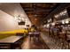 Modern dining area with wood floors, yellow seating, a bar, and multiple TVs at 3653 E Highland Ave, Phoenix, AZ 85018