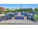 Outdoor fire pit surrounded by Adirondack chairs, with a pool and manicured landscaping in the background at 3653 E Highland Ave, Phoenix, AZ 85018