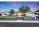 Inviting front exterior of a home featuring a lush lawn, mature trees, and a charming picket fence at 3653 E Highland Ave, Phoenix, AZ 85018