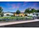 Charming single-story home with manicured lawn, mature trees, and a classic black fence at 3653 E Highland Ave, Phoenix, AZ 85018