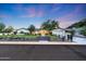 Exterior view showcasing a lush front yard, driveway, and charming fence that enhances the property's curb appeal at 3653 E Highland Ave, Phoenix, AZ 85018