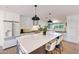Modern kitchen with white cabinets, a large center island with barstool seating, and stainless steel appliances at 3653 E Highland Ave, Phoenix, AZ 85018