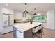 Stylish kitchen featuring white cabinetry, stainless steel appliances, and a spacious island with seating at 3653 E Highland Ave, Phoenix, AZ 85018
