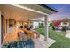 Charming outdoor patio with dining area, fire pit, and view of the home's interior living room at 3653 E Highland Ave, Phoenix, AZ 85018