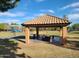 Park pavilion with tile roof and open sides, set in a grassy area near other playground amenities at 3653 E Highland Ave, Phoenix, AZ 85018