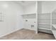 A laundry room with shelves, tile floors, and washer and dryer hookups at 40030 W Agave Rd, Maricopa, AZ 85138