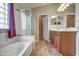 Bathroom boasts a soaking tub, enclosed glass shower, and double sink wood vanity at 40437 W Robbins Dr, Maricopa, AZ 85138