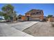 Charming two-story home with a large driveway, two-car garage, and low-maintenance desert landscaping at 40437 W Robbins Dr, Maricopa, AZ 85138