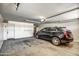 Spacious two car garage with a black SUV parked inside at 40437 W Robbins Dr, Maricopa, AZ 85138