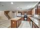 Kitchen with stainless appliances, center island, and tile flooring, connected to the staircase at 40437 W Robbins Dr, Maricopa, AZ 85138