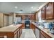 Charming kitchen featuring wooden cabinetry, an island, and tiled floors, offering a blend of functionality and style at 40437 W Robbins Dr, Maricopa, AZ 85138