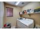 Functional laundry room with a washer, dryer, storage shelf, and a window at 40437 W Robbins Dr, Maricopa, AZ 85138