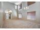 Bright living room with neutral carpet, a high ceiling, with views of the front entry and staircase at 40437 W Robbins Dr, Maricopa, AZ 85138