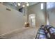 A bright living room featuring soaring ceilings and large windows with wood blinds and carpet flooring at 40437 W Robbins Dr, Maricopa, AZ 85138
