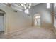 Spacious living room featuring carpet, a high ceiling, with views of the front door and staircase at 40437 W Robbins Dr, Maricopa, AZ 85138