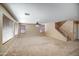 Spacious living room with plush carpeting, natural light, and stairs leading to upper level at 40437 W Robbins Dr, Maricopa, AZ 85138
