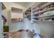 Well-organized walk-in closet featuring shelving and ample storage space for clothes and personal items at 40437 W Robbins Dr, Maricopa, AZ 85138