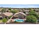 Aerial view of a backyard with a sparkling pool, covered patio, and lush landscaping at 4222 E Torrey Pines Ln, Chandler, AZ 85249