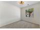 Empty bedroom with carpet flooring, ceiling fan and a street view through the window at 4222 E Torrey Pines Ln, Chandler, AZ 85249