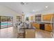 Bright kitchen featuring wood cabinets, a black countertop island with bar seating, and sliding glass doors leading to the pool at 4222 E Torrey Pines Ln, Chandler, AZ 85249