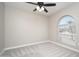This bedroom features neutral walls, a ceiling fan, carpet flooring, and a window for plenty of natural light at 4506 W Golden Ln, Glendale, AZ 85302