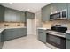 Modern kitchen with olive green cabinets, quartz countertops, and stainless steel appliances at 4506 W Golden Ln, Glendale, AZ 85302