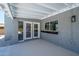 View of the outdoor patio area with white ceiling beams and double door access to the home at 4506 W Golden Ln, Glendale, AZ 85302