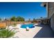 Private backyard showcasing a sparkling pool with a diving board, desert landscaping, and gray house at 4506 W Golden Ln, Glendale, AZ 85302