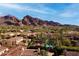 Stunning aerial view of the community with red tile roofs, palm trees, and a mountain backdrop on a sunny day at 4949 E Lincoln Dr # 11, Paradise Valley, AZ 85253