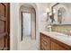Hallway bathroom features a tiled sink and vanity with a decorative mirror and a view of the hallway at 4949 E Lincoln Dr # 11, Paradise Valley, AZ 85253