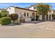 Beautiful exterior of the home with arched entryway, mature landscaping, and a brick driveway at 4949 E Lincoln Dr # 11, Paradise Valley, AZ 85253