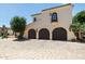 A three-car garage with arched doors sits in front of a home with a tiled roof at 4949 E Lincoln Dr # 11, Paradise Valley, AZ 85253