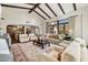 Open living room with beamed ceilings, neutral furnishings, a stone fireplace, and views into the adjacent kitchen and dining room at 4949 E Lincoln Dr # 11, Paradise Valley, AZ 85253