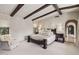 This main bedroom features high ceilings, wooden beams, and a luxury arched doorway at 4949 E Lincoln Dr # 11, Paradise Valley, AZ 85253