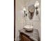 Powder room featuring a stone vessel sink, decorative sconces, and a patterned tile wall at 4949 E Lincoln Dr # 11, Paradise Valley, AZ 85253