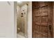 Walk in shower with sandstone tile, frameless glass, wooden door and brushed fixtures at 4949 E Lincoln Dr # 11, Paradise Valley, AZ 85253