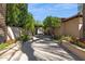 Picturesque walkway lined with trees, flower beds, and stone pavers leading to the property at 4949 E Lincoln Dr # 11, Paradise Valley, AZ 85253