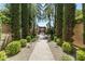 Scenic walkway features lush landscaping, mature trees, and a charming brick entrance gate at 4949 E Lincoln Dr # 11, Paradise Valley, AZ 85253