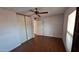 Bedroom featuring wood floors, a ceiling fan, and closet with sliding doors at 5002 W Christy Dr, Glendale, AZ 85304