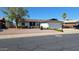 Attractive single-story home with desert landscaping, mature trees, and a two-car garage at 5002 W Christy Dr, Glendale, AZ 85304